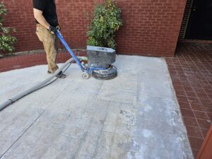 Grinding the concrete to remove existing finish