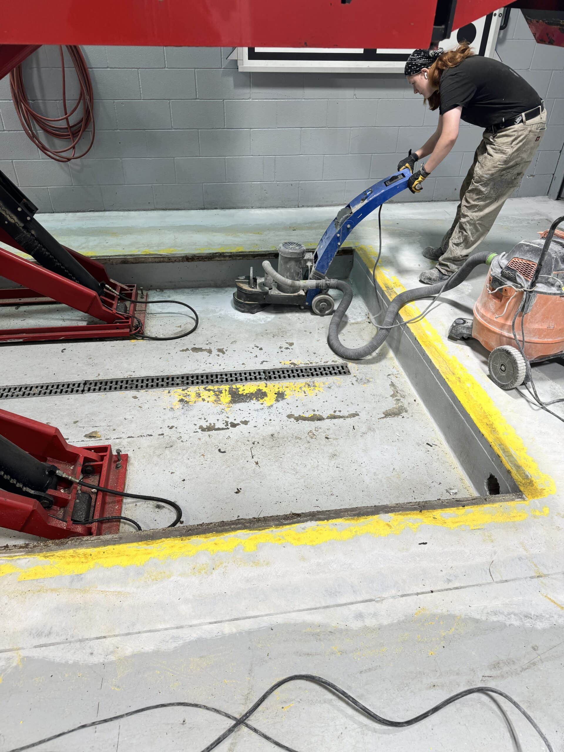 Diamond grinding concrete in an auto service bay before polyaspartic floor coating installation