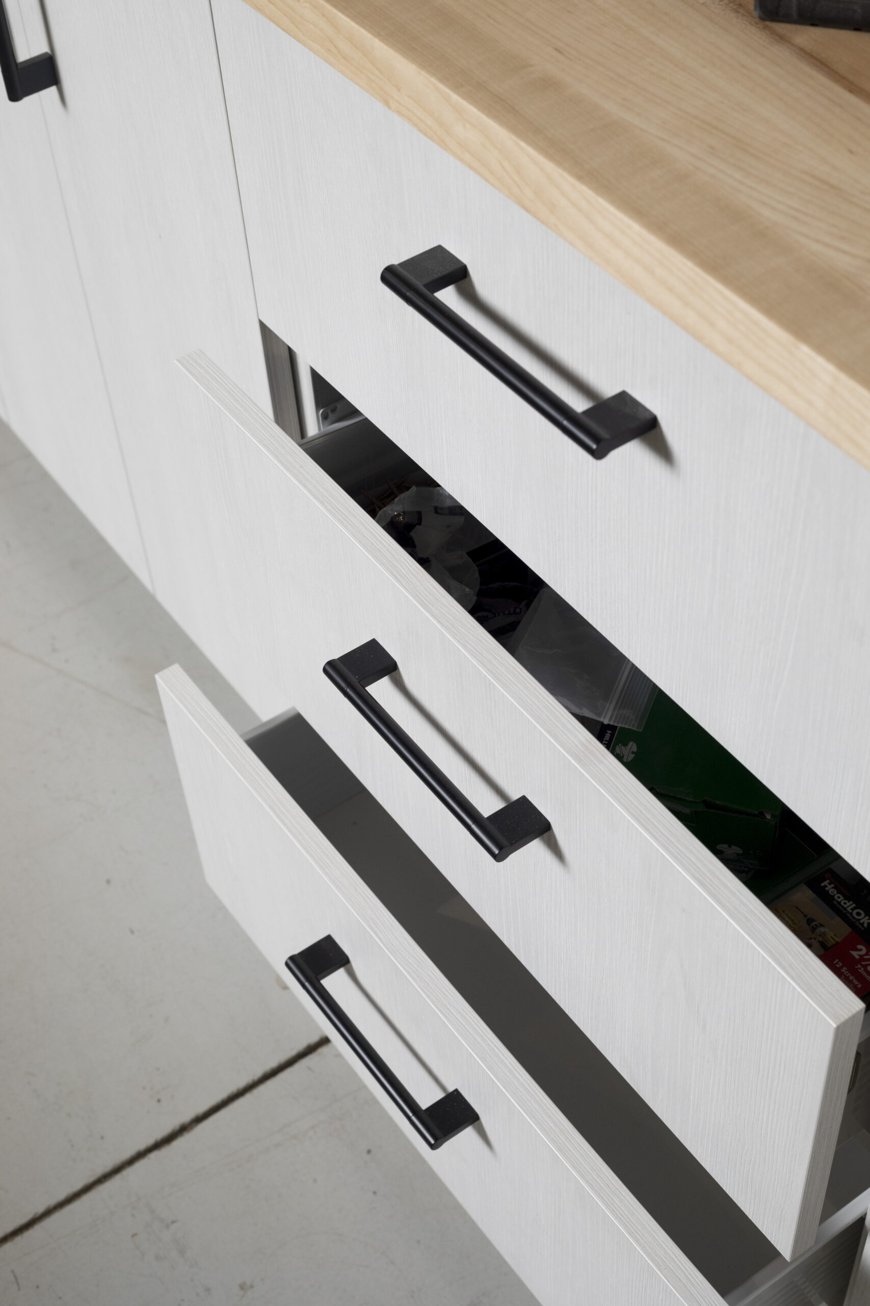 Close-up of white cabinet drawers and commercial-grade hardware — Colorado Springs Garage Floors