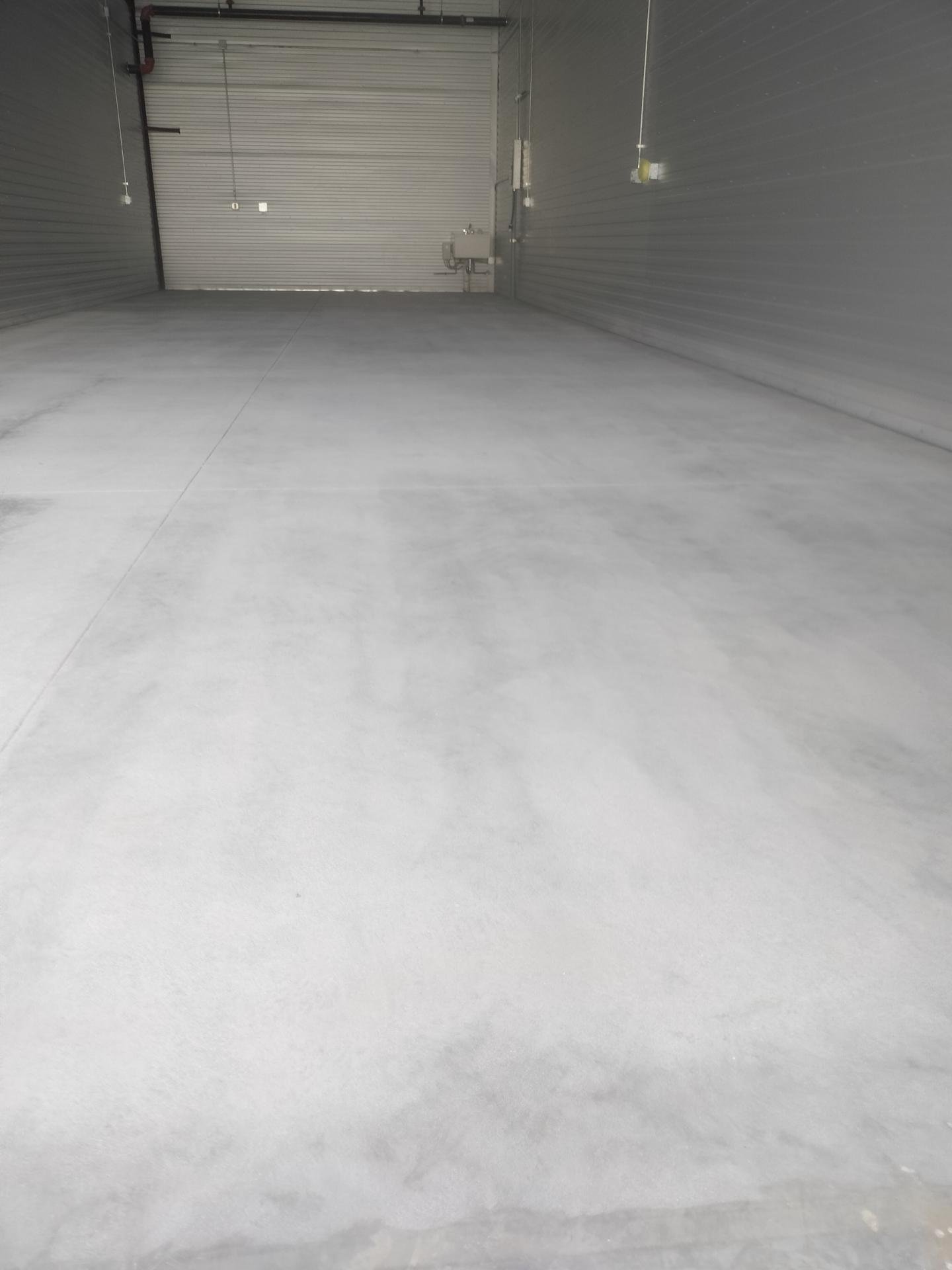 Bare gray concrete floor inside a garage condo in Colorado Springs before polyaspartic coating