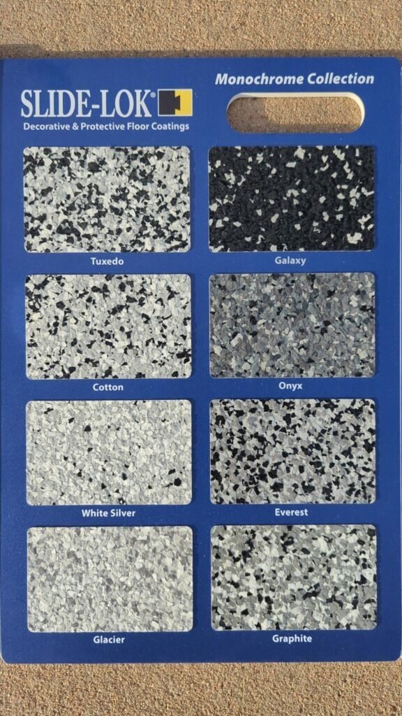 Slide-Lok Monochrome Collection flake sample board showing Tuxedo, Galaxy, Cotton, Onyx, White Silver, Everest, Glacier, and Graphite garage floor blends